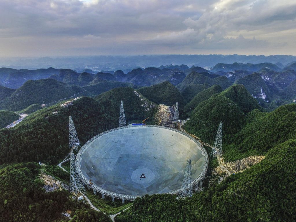 QIANNAN, CHINA - JUNE 10: (CHINA OUT) An aerial view of the Five hundred meter Aperture Spherical Telescope (FAST) on June 10, 2016 in Qiannan Buyei and Miao Autonomous Prefecture, China. After five years of construction, FAST will be completed by August 30, 2016 and will be the world's second largest radio telescope. It is also planned to be developed into a tourist destination. Currently, engineers are finishing the reflection dish and working on the construction of ancillary facilities such as the viewing platform, trail ladder and guesthouse. Farmers who still live in the valleys near FAST are relocating to the new resettlement housing district further away from the telescope. (Photo by VCG/VCG via Getty Images)